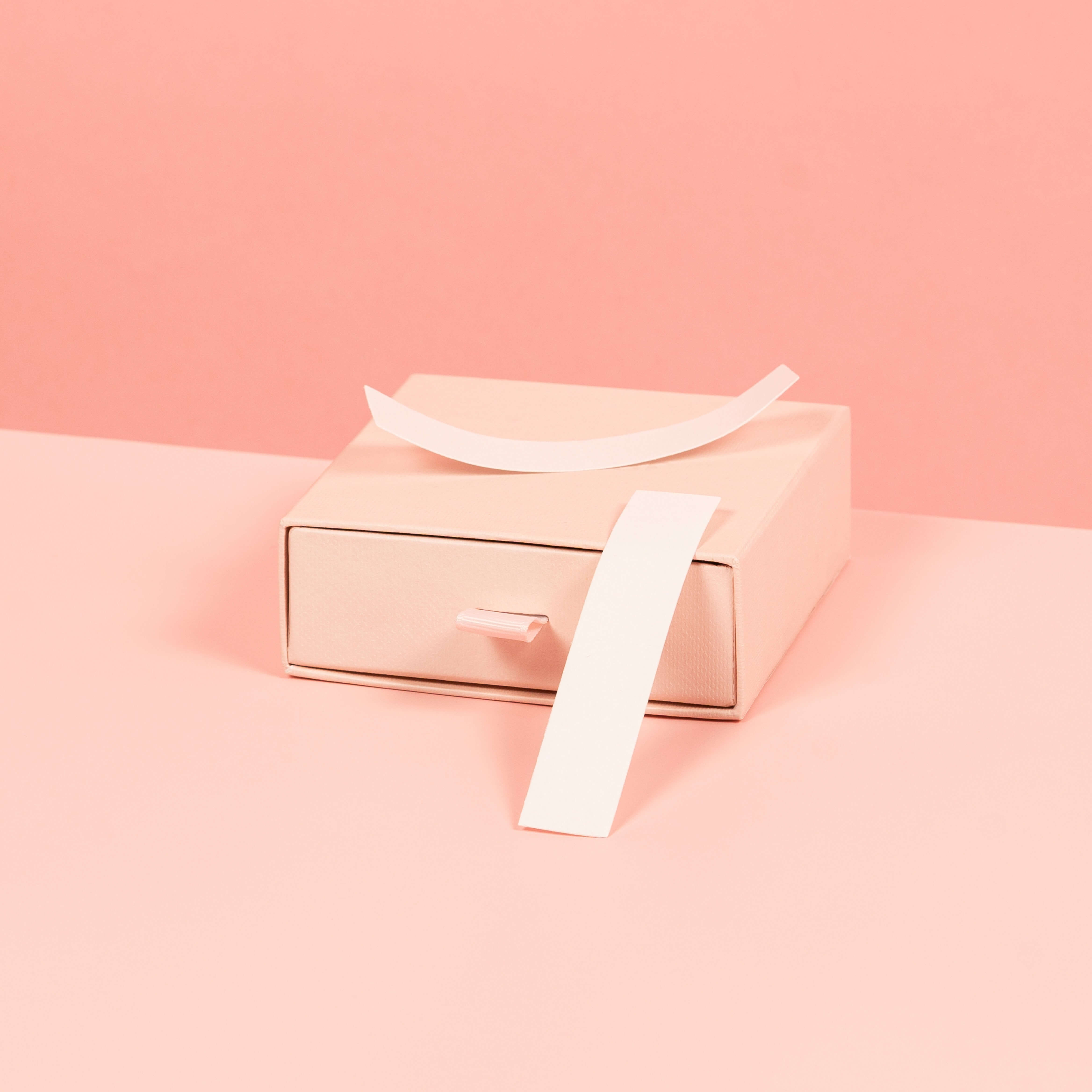 A stylized photo of Brelese Clothing Tape on a pink background.